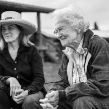 Black and white image of two women sitting down outdoors