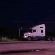 still of female truck driver starring at their truck in the middle of the night