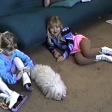 old photo of siblings in cheer outfit sitting on the floor of a living room