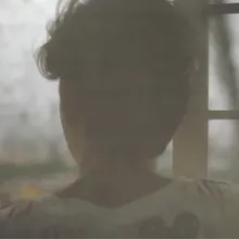 a face stares out the window on a cloudy day