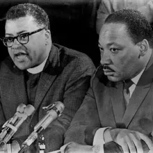 Reverend James Lawson sits and speaks next to Martin Luther King Jr. 