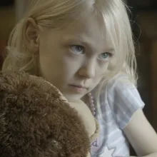 Transgender child and main subject of Mama Bears holding a stuffed toy.