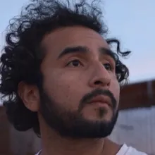 Javier Zamora stands near the wall built on the USA - Mexico Border as he searches for the place through where he crossed as a child. 