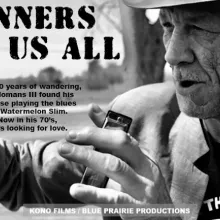 Watermelon slim holds a harmonica and speaks into distance in a black and white photo.