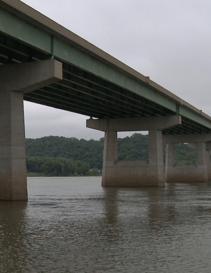 A shot of a bridge over a river taken from below on a grey cloudy day