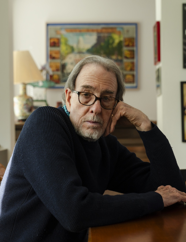 A white man sits at his dining room table.