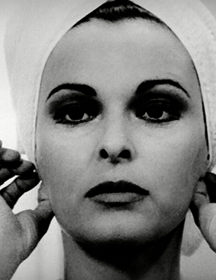 Black and white close-up of a beautiful white woman with lipstick as she adjusts the towel in her hair with her hands
