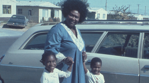 Ruby Duncan holding hands with two children in front of an old station wagon on the historically Black West Side of Las Vegas, c. 1972 